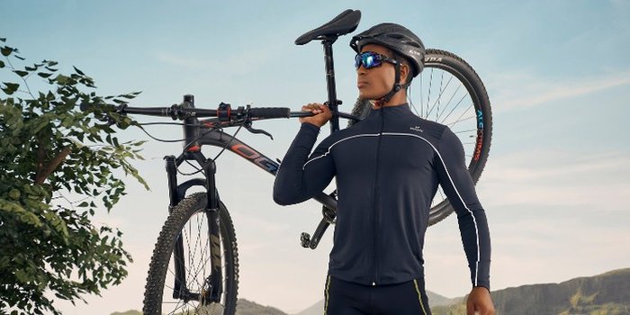 homem com roupas de ciclista segurando bike